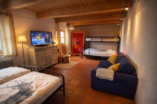 a living room with a couch and a bed in a room at Gibbesbachhof Black Forest Apartments in Triberg