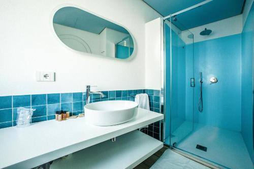 a bathroom with a sink and a glass shower at Hotel New Barcavela in Santa Margherita di Pula