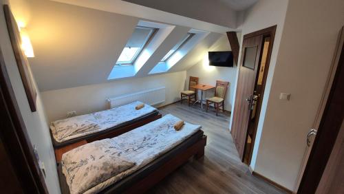 a room with two beds and a table with a chair at Noclegi Tyczyn in Tyczyn