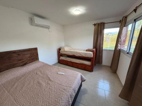 a small bedroom with two beds and a window at Casa con pileta cerca de Salta in Salta