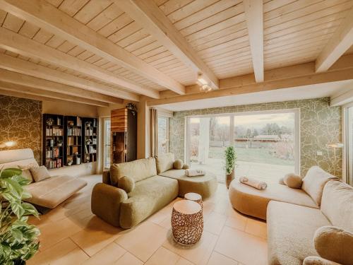 a living room with couches and a large window at Schäfers - Ihr Wohlfühlort, Ferienwohnungen & Ferienhaus am Naturteich an 2 Seen bei Leipzig in Großpösna