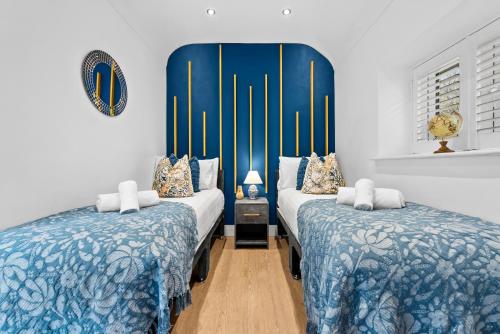 two beds in a room with blue and white at The Oak Sty - 2 Bed Countryside Cottage Escape in Durley with Hot Tub, Unique rural retreat, Private Parking, Sleeps 4 & Pet friendly - By Blue Puffin Stays in Southampton
