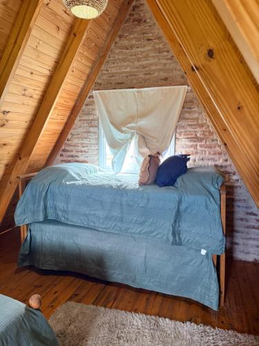 a bed in a attic room with a window at Salesta San Pedro in San Pedro