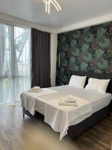a bedroom with a large bed with a floral wall at Sun Beach Hotel Grigoleti in Grigoleti