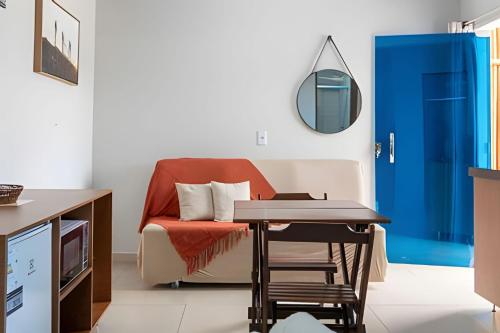 a living room with a chair and a table at Recanto Sol da Chapada | Aptos no Centro com Garagem e Café da Manhã in Alto Paraíso de Goiás