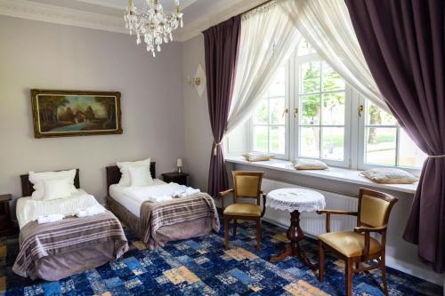 a bedroom with two beds and a window at Hotel Dwór Sójki in Sójki