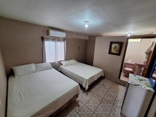 a hotel room with two beds and a window at Tu casa en Omoa in Omoa