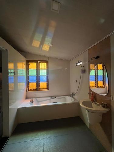 a bathroom with a large tub and a sink at Fort flora in Cochin