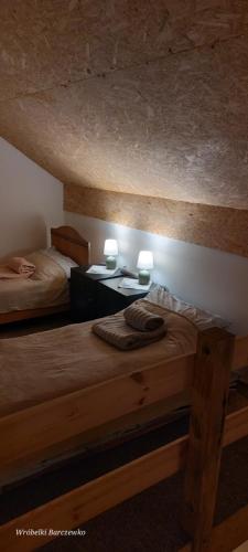 a bedroom with two beds and two tables with lamps at Chata pod kogutem in Barczewko