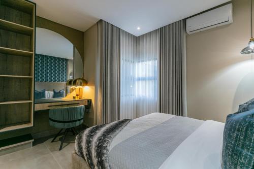 a hotel room with a bed and a desk at Ditsametse Luxe Suites in Gaborone