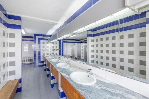 a bathroom with a row of sinks and mirrors at HI Castelo Branco - Pousada de Juventude in Castelo Branco