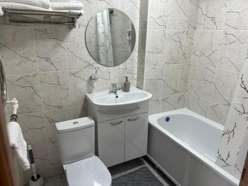 a bathroom with a toilet and a sink and a mirror at KOLESEY Hotel in Taldykorgan