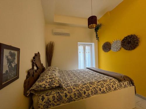 a bedroom with a bed in a room with yellow walls at Porto Antico in Bari