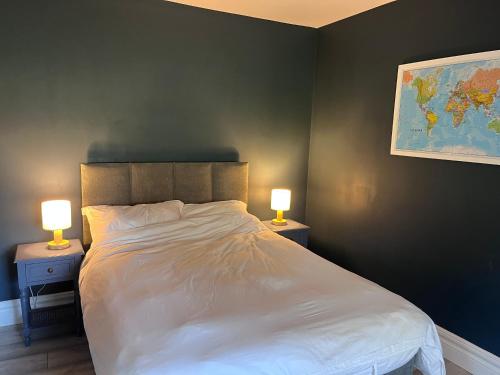 a bedroom with a large bed with two lamps on tables at Teresa's Cottage in Kilcolgan