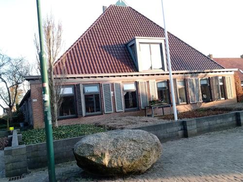 a large rock in front of a house at 't Griene Hemeltsje in Wijckel