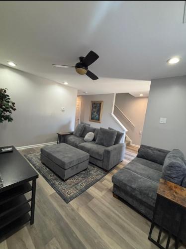a living room with two couches and a ceiling fan at Riverside Retreat in Camden