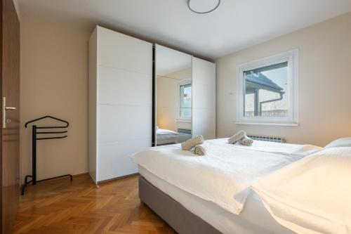 a bedroom with a large bed and a mirror at Jacuzzi, BBQ & EV plug - 5BR Villa Villi with Garden in Limbuš
