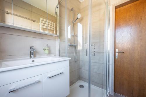 a bathroom with a sink and a shower at Jacuzzi, BBQ & EV plug - 5BR Villa Villi with Garden in Limbuš
