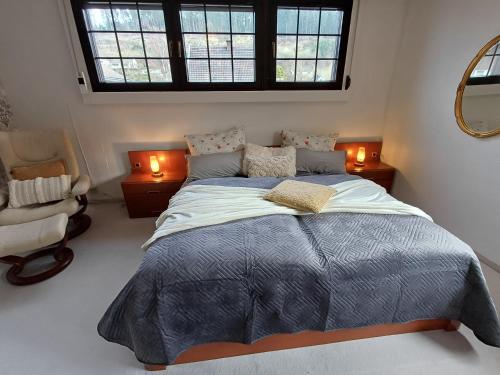 a bedroom with a bed and a chair and a window at ZusammenZeit in Schleiden - inklusive Sauna, Garage, großer Terrasse und 3 Schlafzimmer - ideal für Familien und Freunde - Hunde freundlich in Schleiden