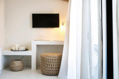 a living room with a television and a white curtain at Kefalonia Grand in Argostoli