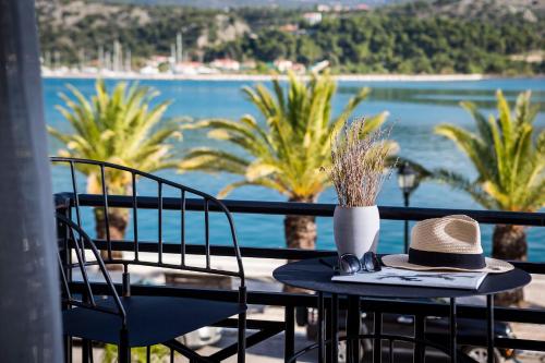 a table with a hat and two chairs on a balcony at Kefalonia Grand in Argostoli