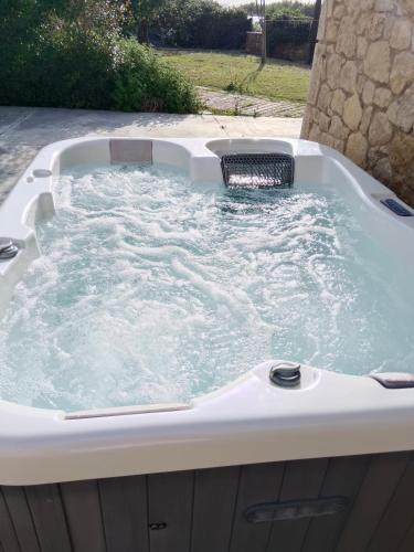a jacuzzi tub in a yard with at Villa Penelia next to golf courses in Romanu