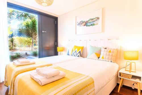 a bedroom with a large bed and a window at Troia Ocean Breeze Villa in Troia