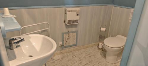 a bathroom with a sink and a toilet at Les Chambres du Relais in Liettres