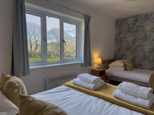 two beds in a room with two windows at Beachcomber in Croyde