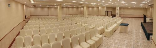 an empty hall with white chairs and a stage at Radisson Hotel & Convention Center Toluca in Toluca