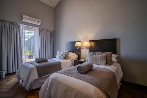 a hotel room with two beds and a window at Playas Art Hotel in Pinamar