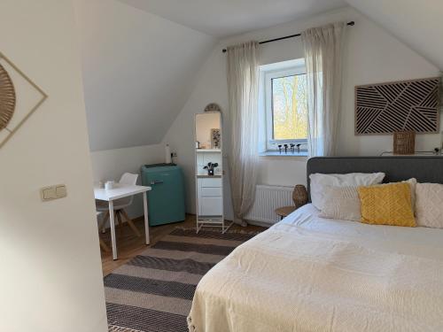 a bedroom with a bed and a table and a window at Deich Winde 9.1 in Dorum-Neufeld