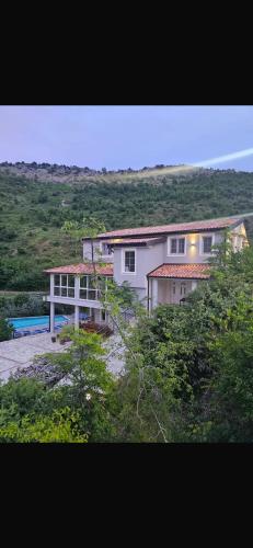a large white house in the middle of a field at Qyteza guest house in Shkodër