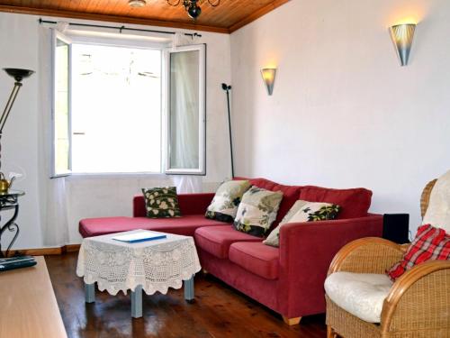 a living room with a red couch and a table at Comme chez Mamie Albi - Terrasse - Proche Centre in Albi