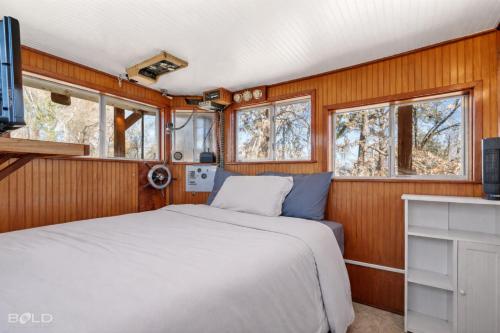 a bedroom with a bed and some windows at Shipwreck with upper deck, Dock Access, Kayaks in Karnack