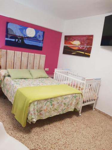 a bedroom with two beds and two pictures on the wall at Duplex en El Pouet, con ascensor in Sueca