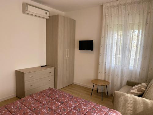 a bedroom with a bed and a couch and a dresser at Cygnus Bed & Breakfast in Lido di Jesolo