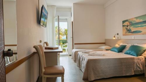 a hotel room with two beds and a desk at Hotel Internazionale in Marotta