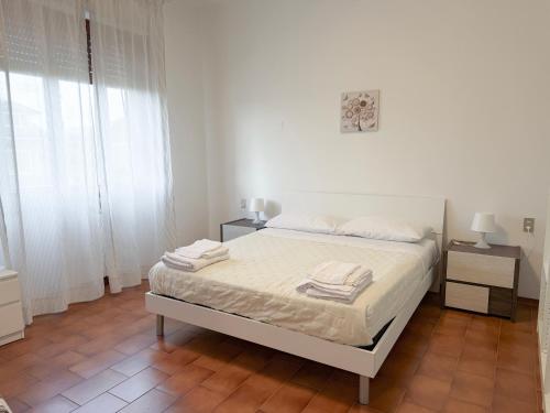 a white bedroom with a bed and two night stands at Da Vinci Rooms in Vinci