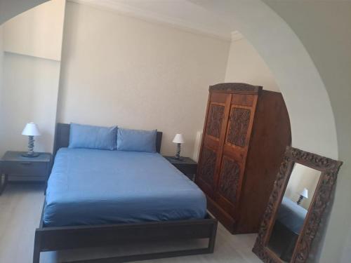 a bedroom with a blue bed and a mirror at 210 on Main in Kalk Bay