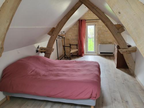 a bedroom with a red bed in a attic at Mon Cabanon in Tonnerre