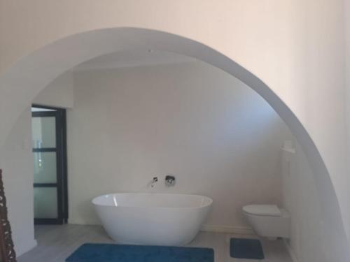 a white bathroom with a sink and a toilet at 210 on Main in Kalk Bay