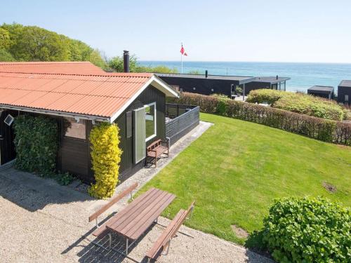 a house with a picnic bench and the ocean at 5 person holiday home in Juelsminde-By Traum in Sønderby