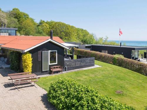 a small house with a picnic bench in a yard at 5 person holiday home in Juelsminde-By Traum in Sønderby