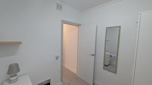 a white bathroom with a mirror and a toilet at Casa Ursula in Los Alcázares