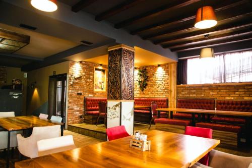 a restaurant with a wooden table and red chairs at Hotel & Restaurant Carevoselski in Delčevo