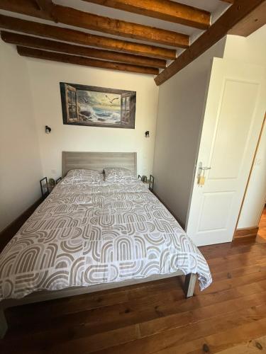a bedroom with a bed with a comforter at La maisonnette in Coulombs