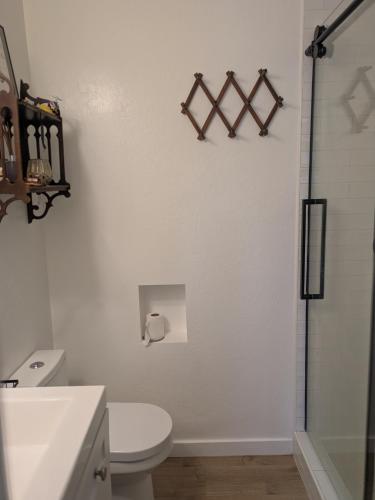 a white bathroom with a toilet and a shower at Casa Dorado - Bright, Sunny 2 Bedroom 1 Bath House - Fenced Yard, Private Patio in Santa Barbara
