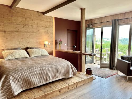 a bedroom with a large bed and a desk andwindows at Domaine Aari Ona in Aramits