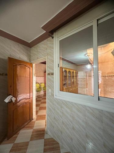 a room with a large window and a room with a hallway at Appartement champs élyséen in Berkane